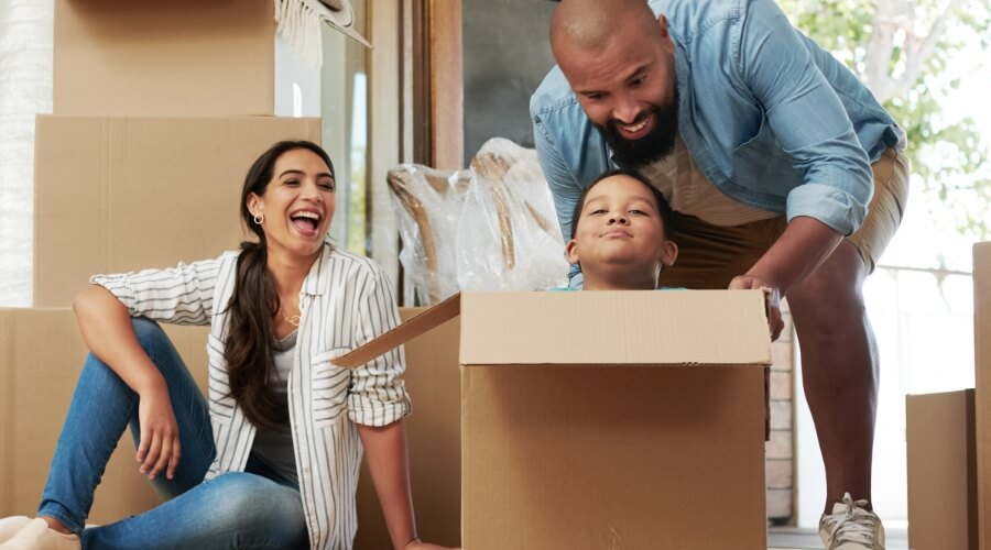 Cheerful family unpacking in their new home, enjoying the peace of mind that comes with a fixed-rate mortgage wit Civic Credit Union.