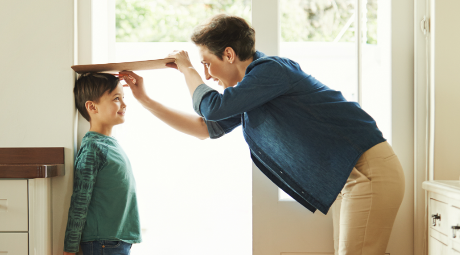  A mother marks her son's height on the wall, tracking his growth—just like the Civic Choice Certificate helps track your financial progress.