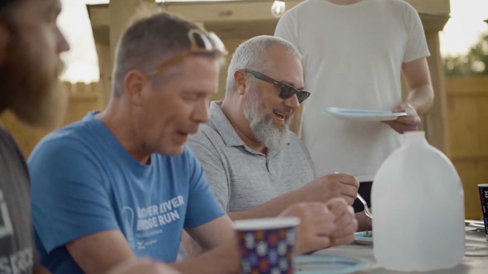 Two men sitting at a table eating