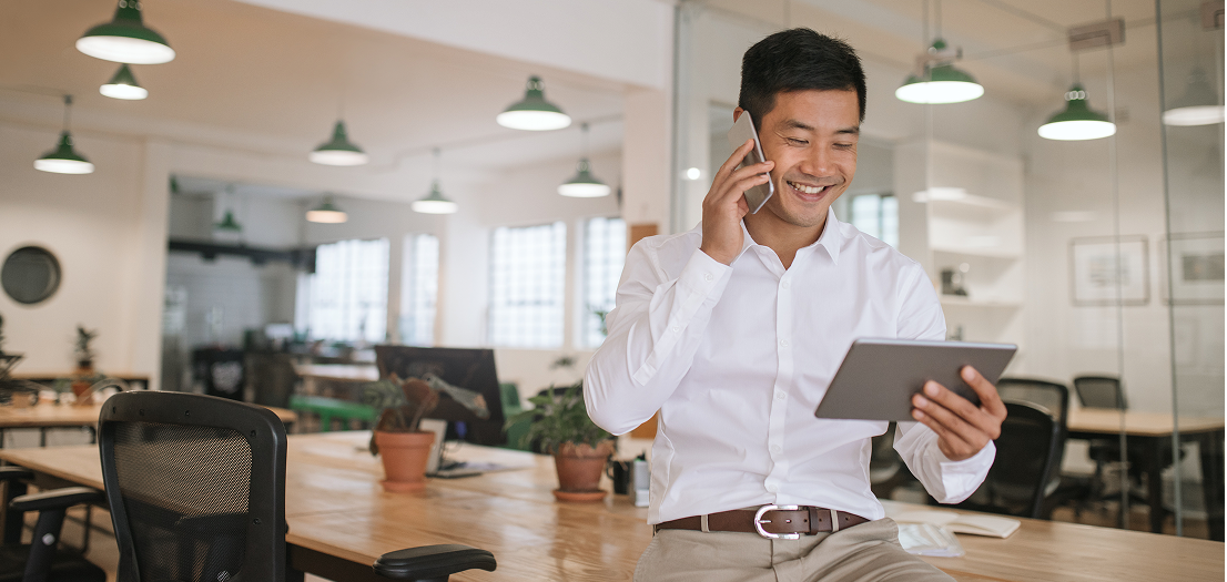 Man looking at his tablet while on the phone