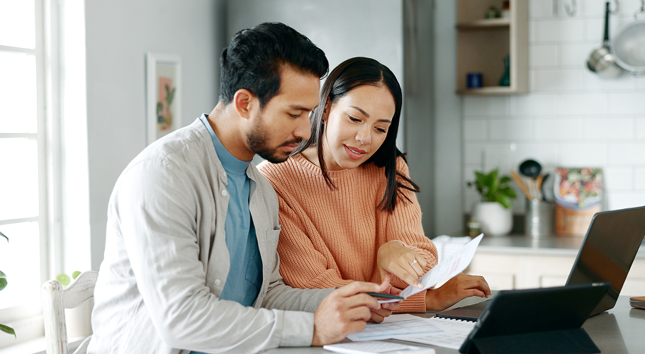 A couple reading over documents in their kitchen