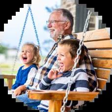 Grandpa with his grandkids swinging on a porch swing. 