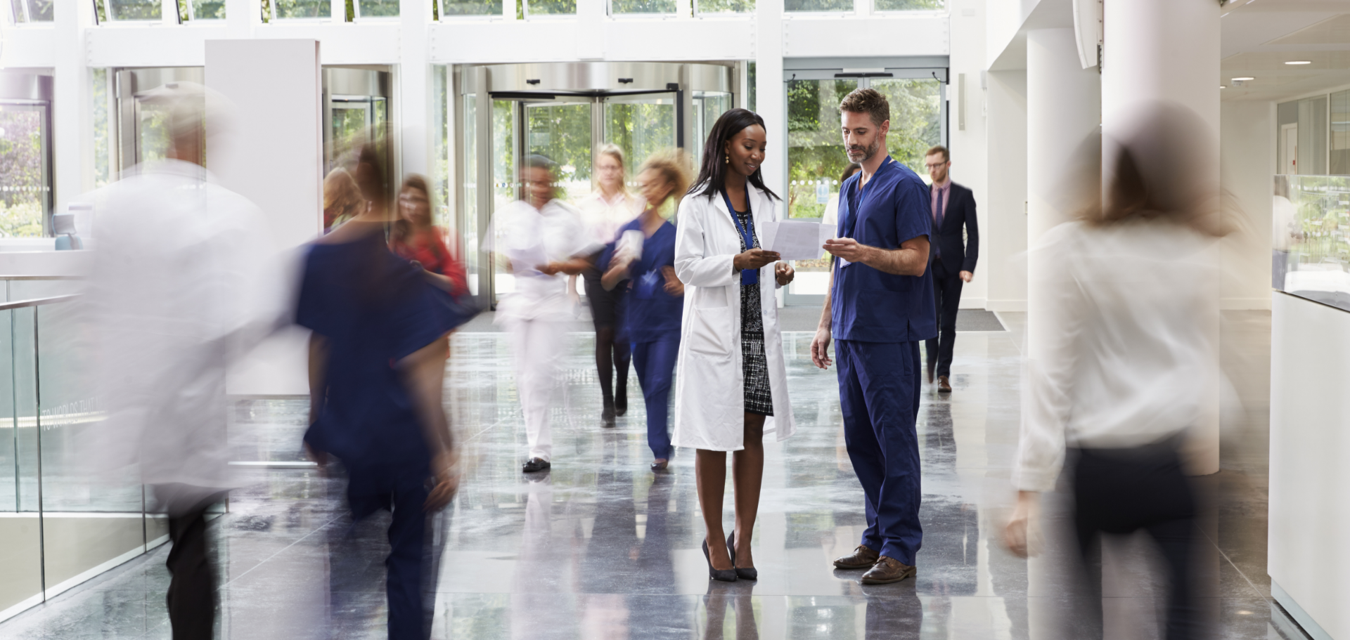 Healthcare workers and volunteers discussing the benefits of Civic membership in a busy hospital setting.