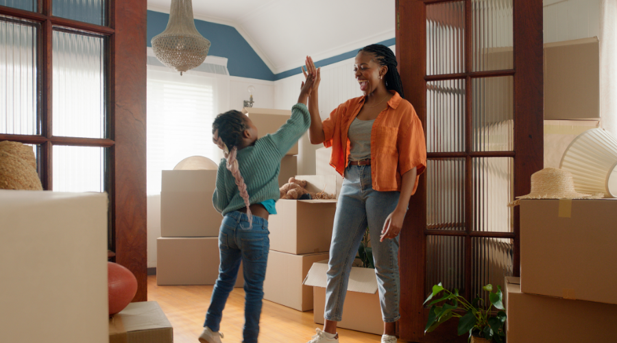 Veteran mom high fiving her daughter after moving into their new home.