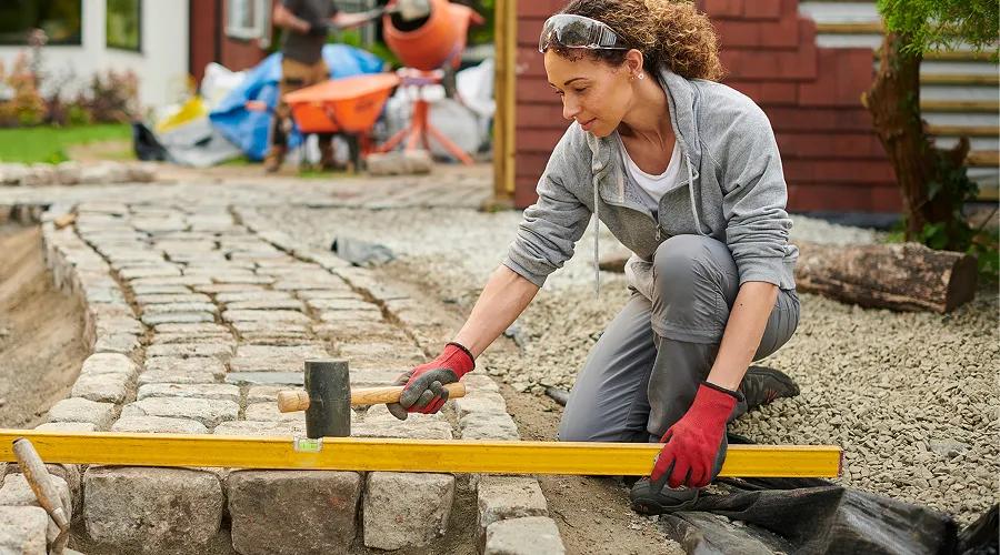 Homeowner installing a cobble path thanks to Civic's HELOC loan. 