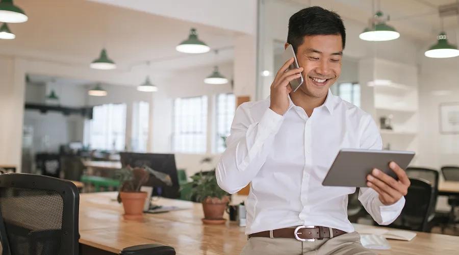 Man looking at his tablet while on the phone