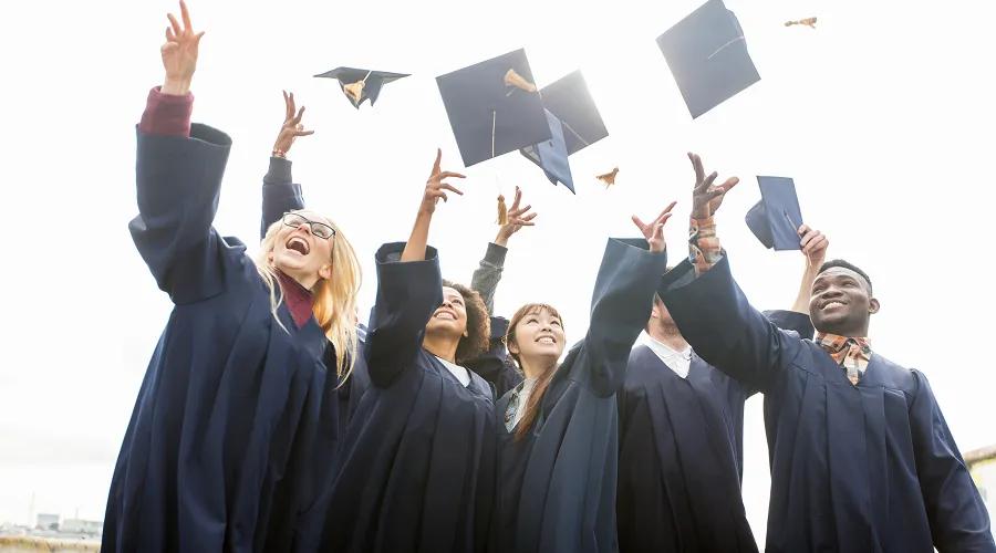 a group of graduates throwing their graduation caps in the air