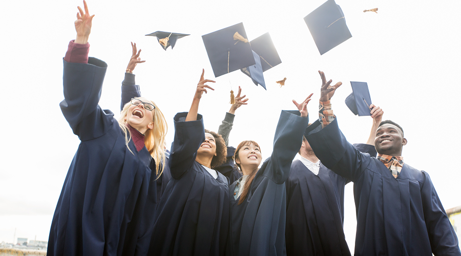 a group of graduates throwing their graduation caps in the air