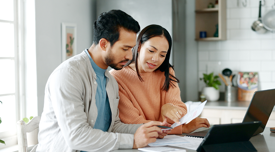 A couple reading over documents in their kitchen