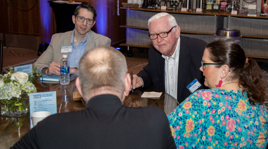 A group of people sitting at a table talking