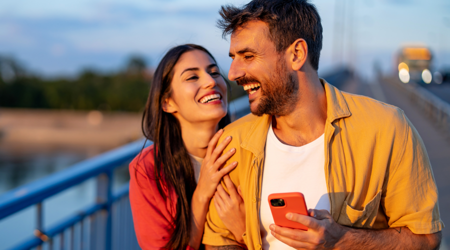 Couple checking there Civic Choice Certificate account on there mobile device with enjoying a summer walk.