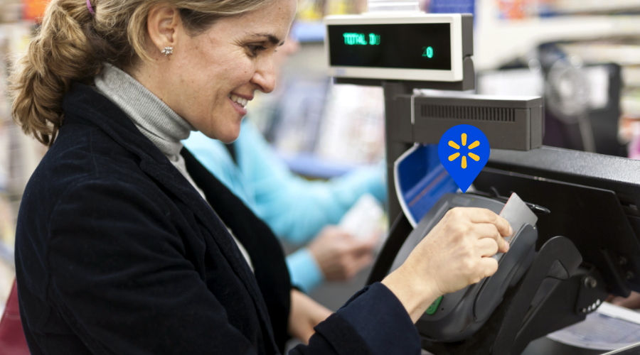 Woman swiping her debit card at a Walmart to deposit cash.