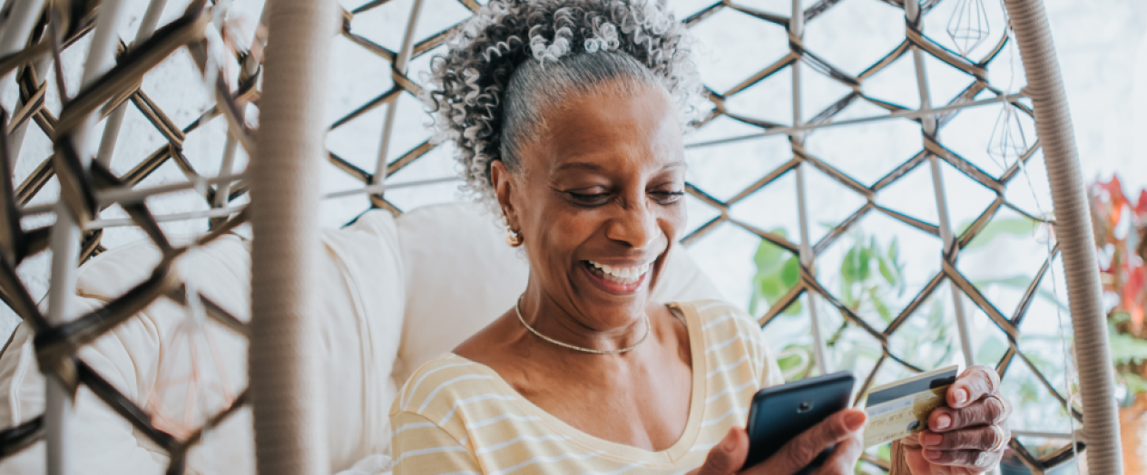 Older woman activating her new Civic Debit card while swinging on her front porch. 