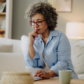 Older mature woman looking over her finances and comparing choice certificates. 