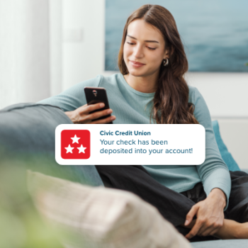Woman receiving a push notification alerting of direct deposit into account.
