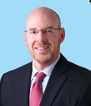 Chris Madsen headshot on a blue background.
