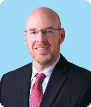 Chris Madsen headshot on a blue background.