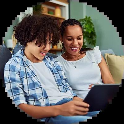 Parent with her teen son looking at credit cards online.