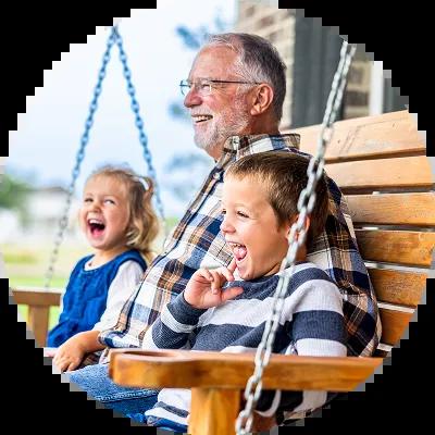 Grandpa with his grandkids swinging on a porch swing. 