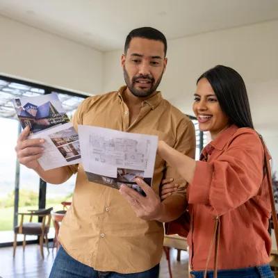 Couple looking over housing floor plans for a new Home