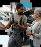 Auto mechanic talking to a female customer about the damage repairs to her car. 