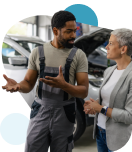Auto mechanic talking to a female customer about the damage repairs to her car. 