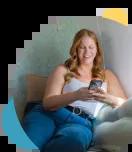 Woman on her phone, checking the Civic app in the comfort of her own home. 