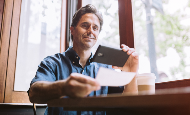 Small business owner depositing check into his Business Checking Account.
