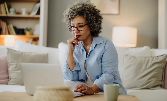 Older mature woman looking over her finances and comparing choice certificates. 