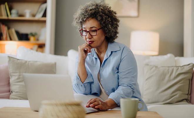 Older mature woman looking over her finances and comparing choice certificates.