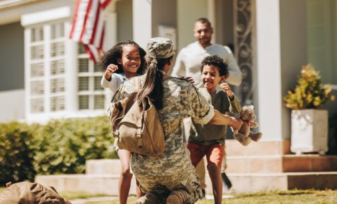 A family welcoming service woman to their new Home financed by Civic Credit Union.