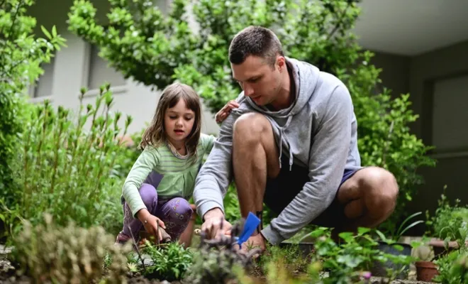 Civic member gardening with his daughter knowing they are getting the best rate on their mortgage.