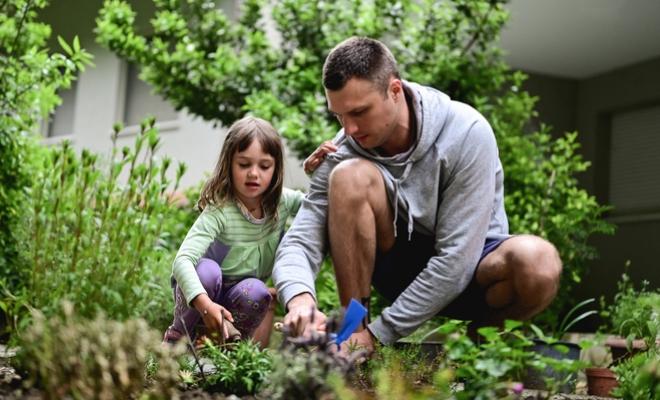 Civic member gardening with his daughter knowing they are getting the best rate on their mortgage.