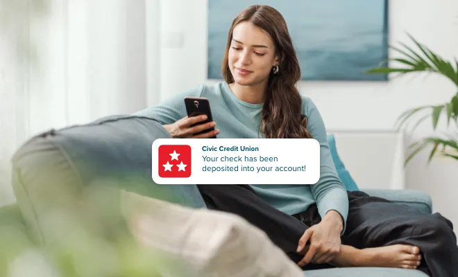 Woman receiving a push notification alerting of direct deposit into account.