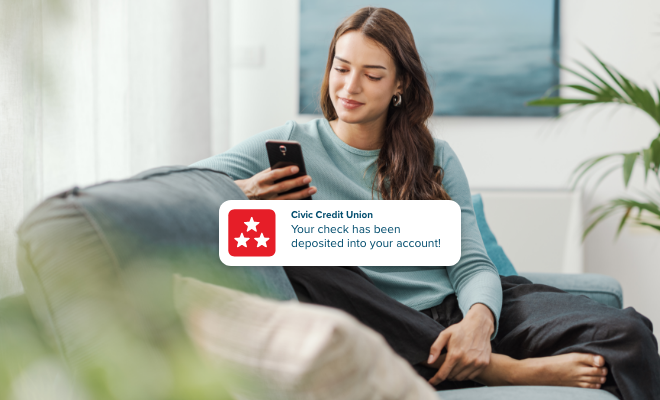 Woman receiving a push notification alerting of direct deposit into account.