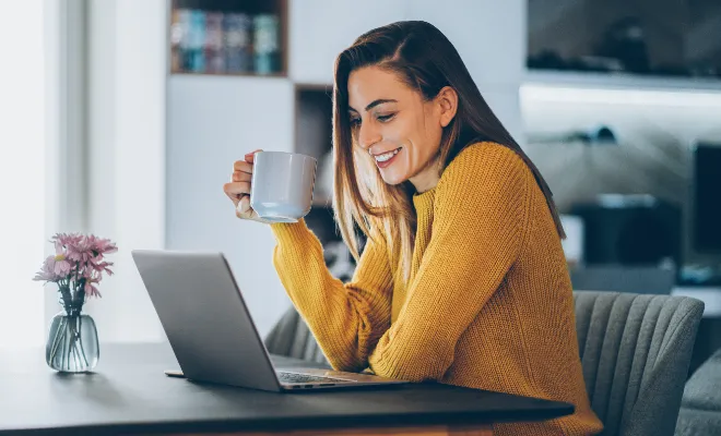 A woman sits at her laptop, signing up for Civic Credit Union by opening a Select Savings Account online.