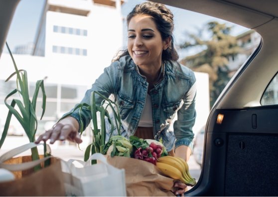 Woman adding groceries to her car