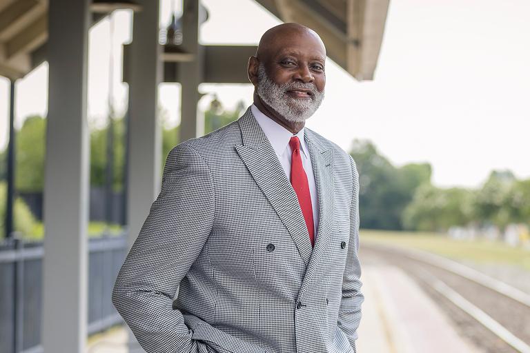 Civic's chairman of the board Dr. Aaron Noble standing next to trains tracks in Burlington, NC.