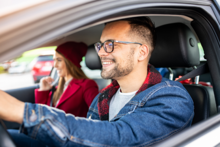 Couple driving in their car knowing they have lowered their payment by refinancing their car loan with Civic Credit Union.