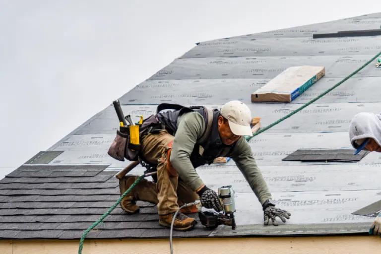 Man fixing a roof after natural disaster.