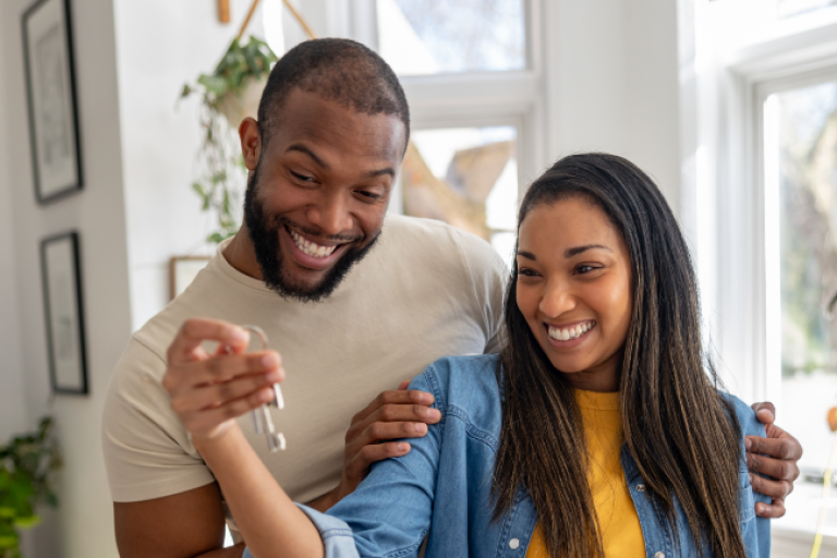 Couple showing off the keys to their new home.