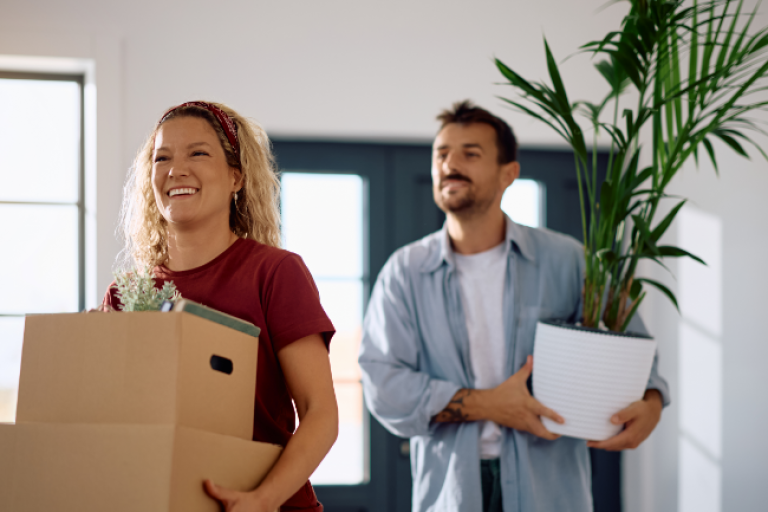 Young woman buying her first home, bringing in boxes.