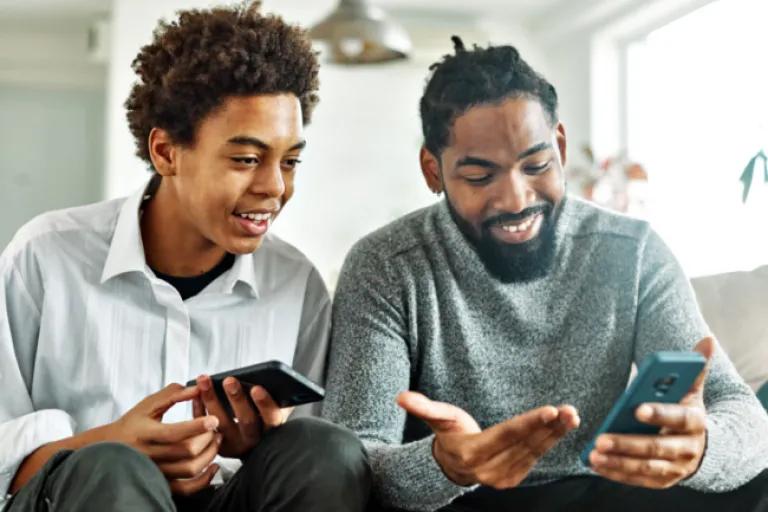 Father teaching his teenage son how to save money using the Civic mobile app and NextGen Savings account.