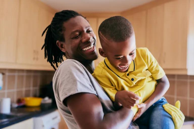  A dad plays with his son, feeling confident and happy knowing his credit score has improved, thanks to Civic's Credit Builder Loan.