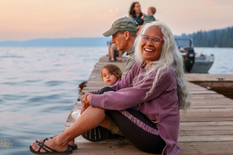 Retired woman enjoying her family by the lake, all thanks to her Civic IRA Choice Certificates