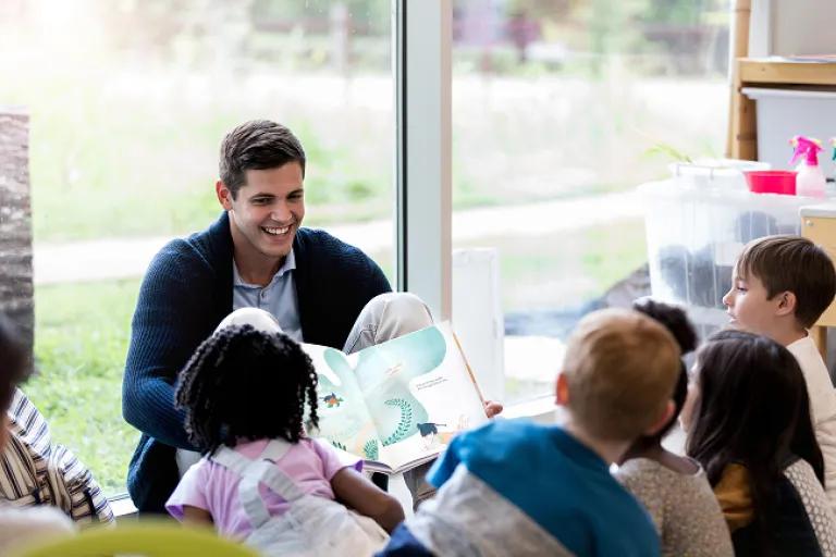 Librarian helping kids find a book to checkout. 