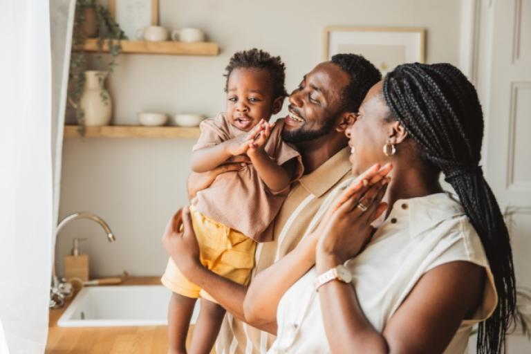 Happy young family playing in the kitchen.