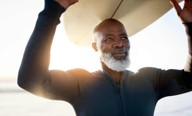 Senior man happily enjoying his retirement by surfing, thanks to his IRA retirement account with Civic.